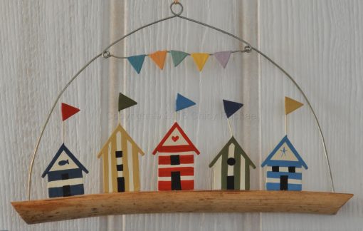 Five Coloured Beach Huts On Driftwood
